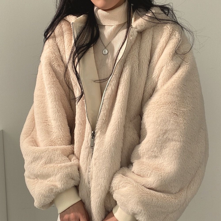 Flauschige Fellseite der Wendejacke in Beige, Nahaufnahme am Reißverschluss