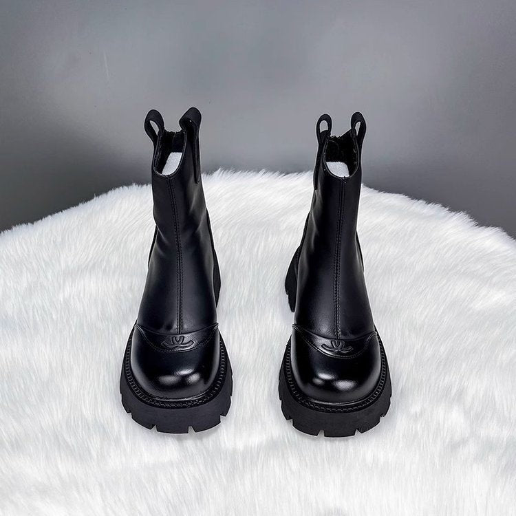 Schwarze Chelsea-Boots mit geprägter Zehenkappe auf Kunstfell präsentiert