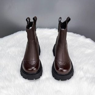 Braune Chelsea-Boots mit strukturierter Sohle auf Kunstfellhintergrund