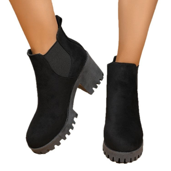Paar schwarze Chelsea-Boots mit Blockabsatz von hinten fotografiert