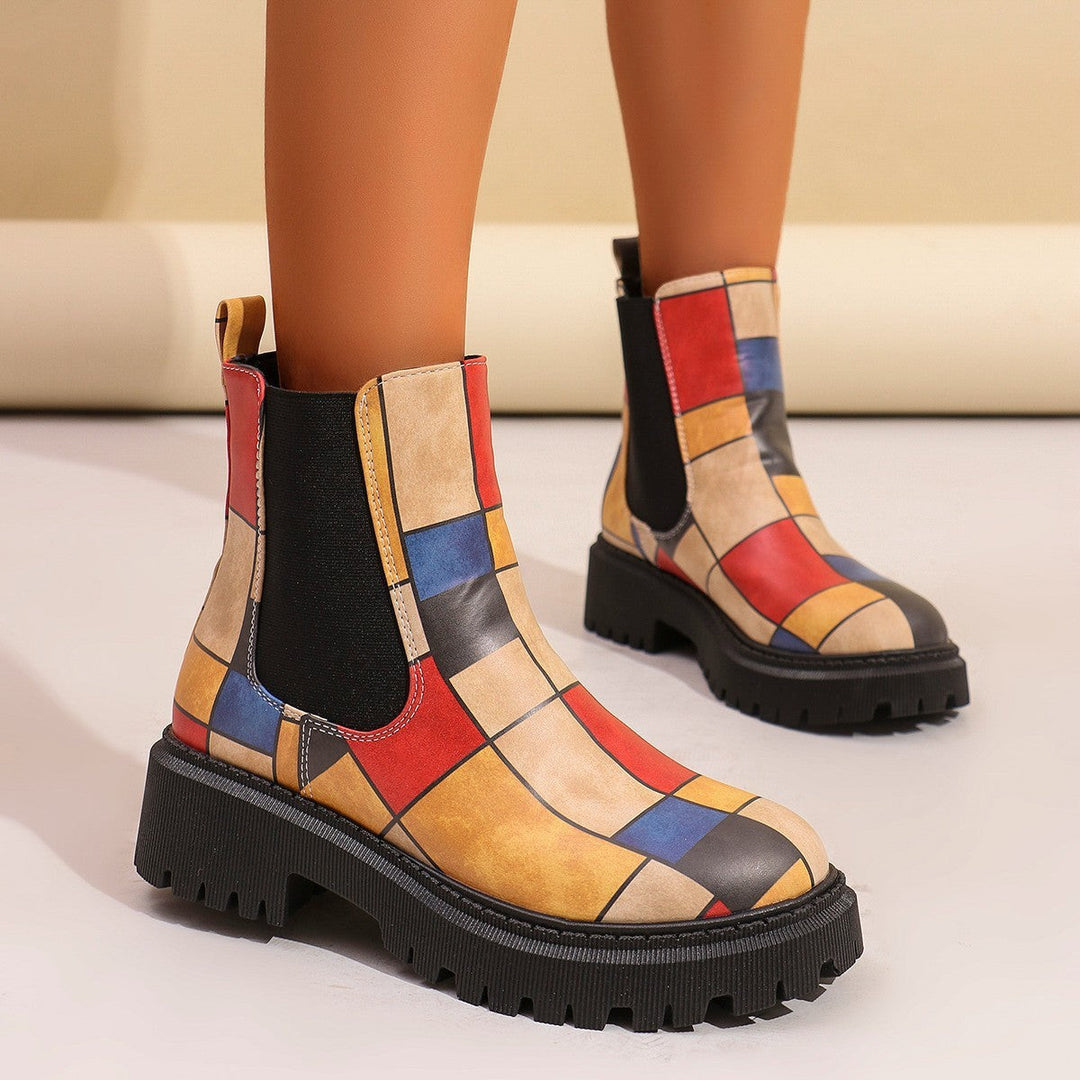 Bunte Chelsea-Boots mit geometrischem Patchwork-Muster an Beinen getragen