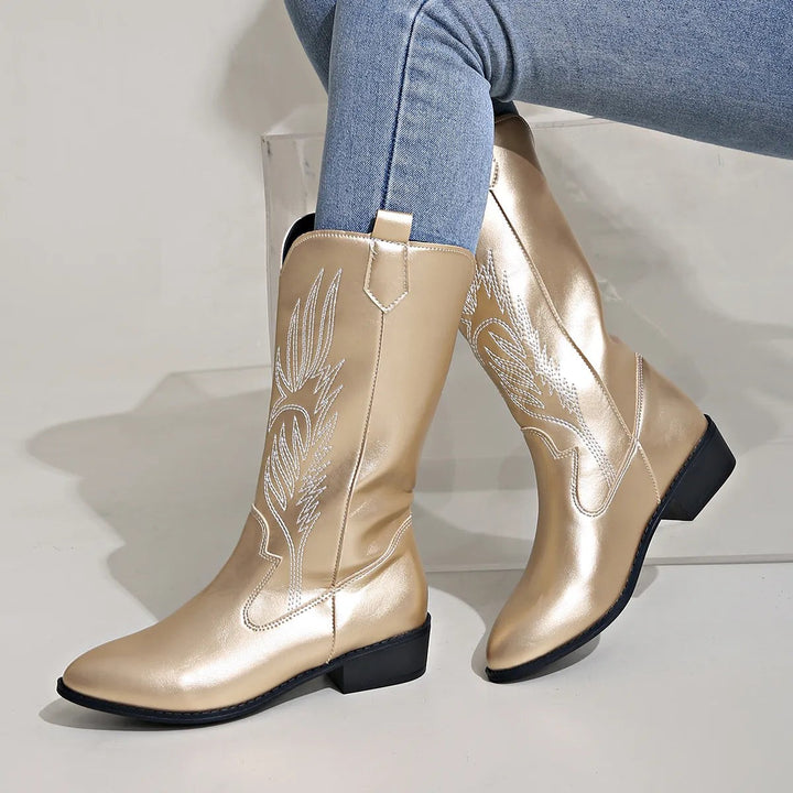Goldene Cowboystiefel mit Stickmuster und spitzer Zehenform an Modell