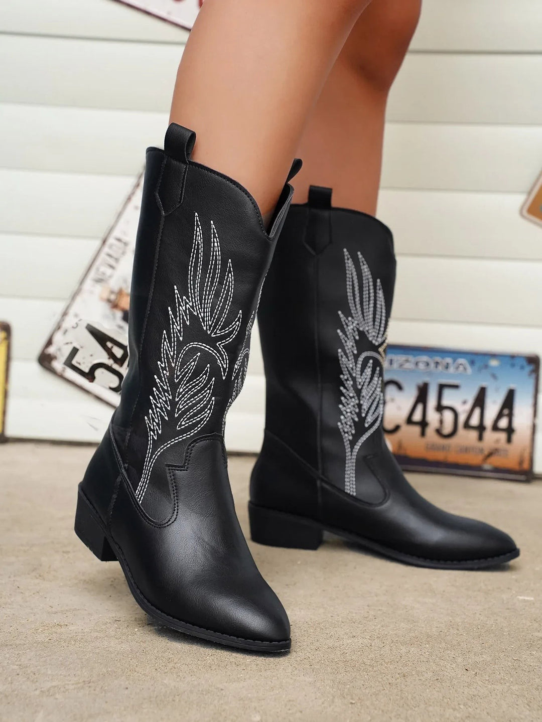 Silberne Westernstiefel mit Stickmuster, Nahaufnahme beim Überstreifen