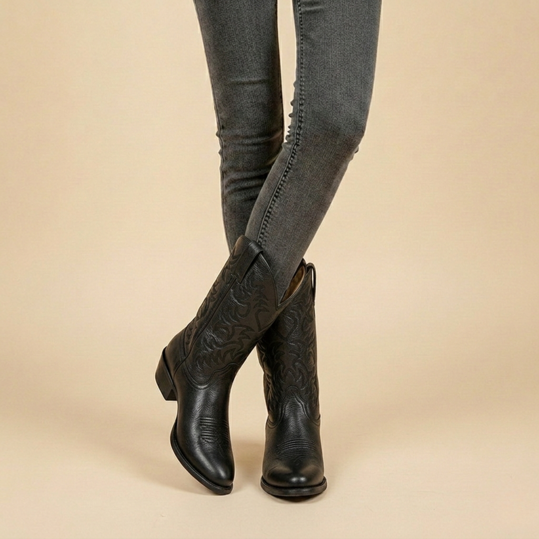 Schwarze Cowboystiefel aus Leder mit Stickmuster, getragen zu grauer Jeans