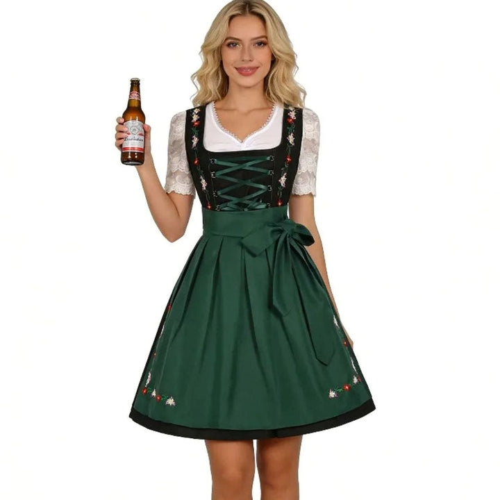 Blondes Model trägt grünes Dirndl mit Spitzenbluse und Schürzenschleife, Bierflasche in der Hand