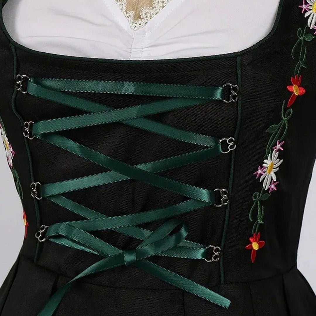 Nahaufnahme Mieder mit grüner Schnürung und bunter Blumenstickerei am Dirndl