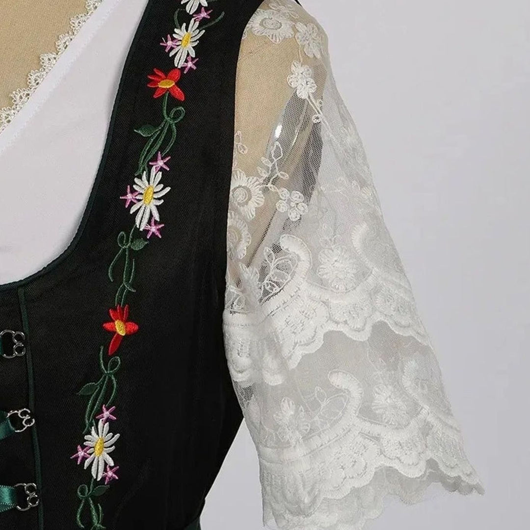 Detailansicht Blumenstickerei am Dirndlträger neben transparentem Spitzenärmel