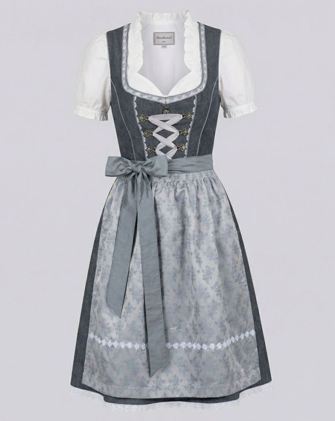 Dreiteiliges Dirndl-Set mit Schürze und Bluse auf grauem Hintergrund