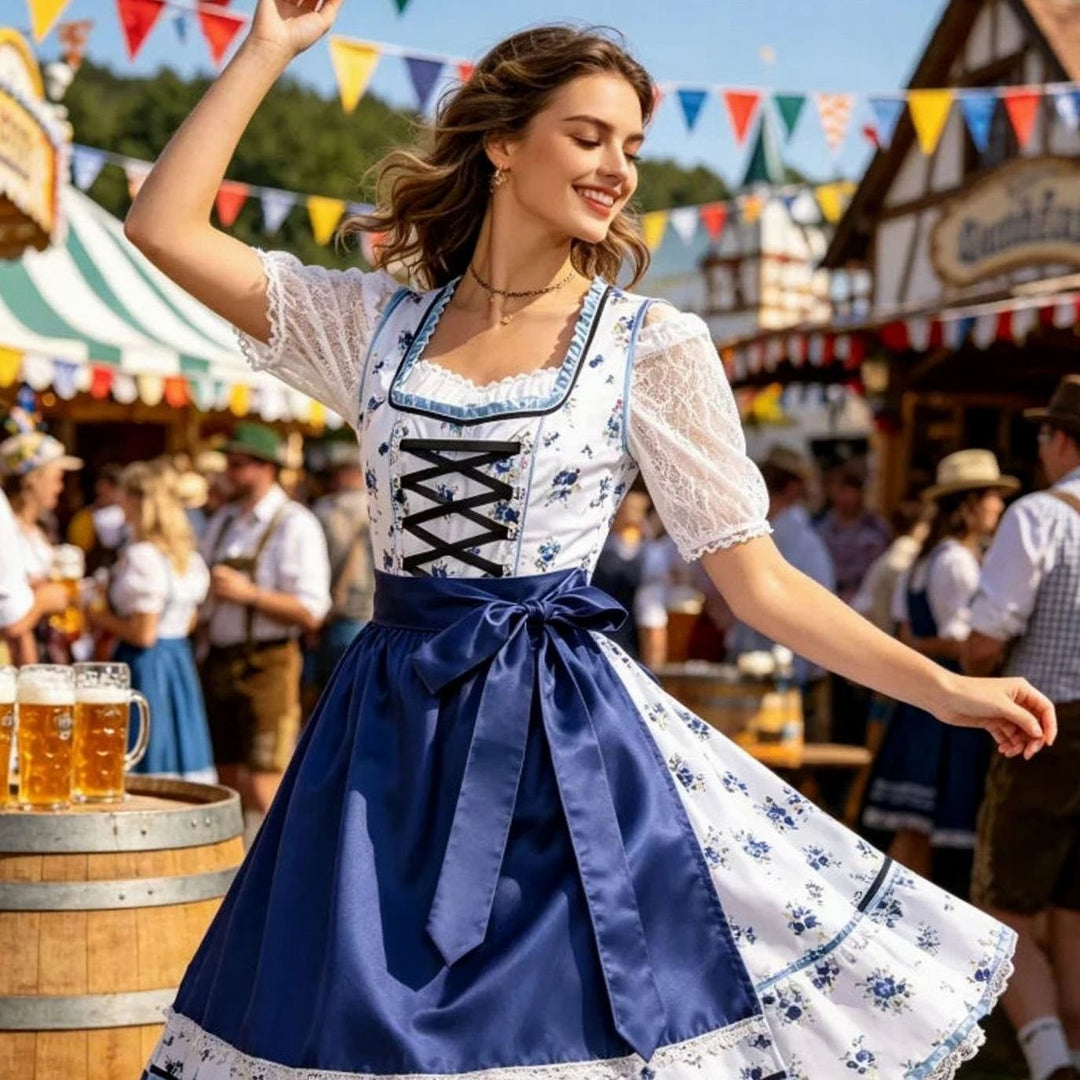 Dirndl mit blauem Blumenmuster und Spitzenbluse beim Oktoberfest getragen