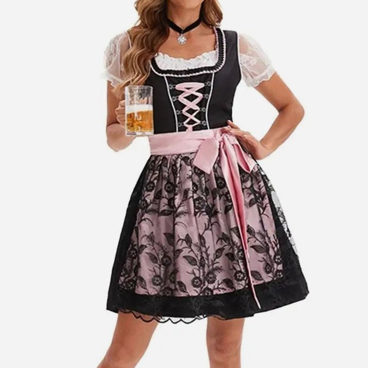 Schwarzes Dirndl mit rosa Schleife und floraler Spitzenschürze
