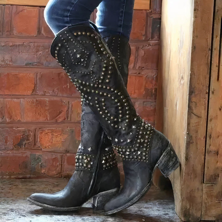 Schwarze Cowboystiefel mit auffälligem Nietenmuster und Absatz