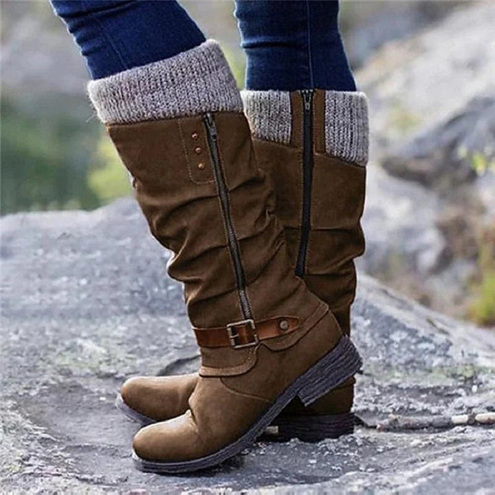 Cognacfarbener Wildlederstiefel mit Strickbündchen am Fels getragen