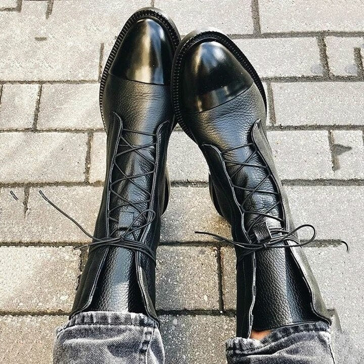 Schwarze Lederstiefel mit Schnürung und glänzender Kappe, getragen mit Jeans