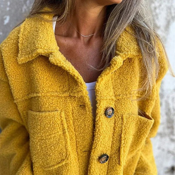 Nahaufnahme gelber Wolljacke mit Knopfleiste und Fellstruktur