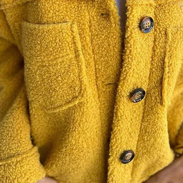 Detailansicht Knöpfe und Tasche einer gelben Kurzjacke aus Teddyfleece