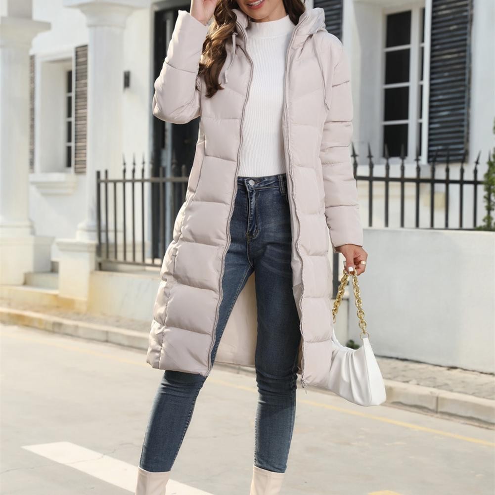 Beige lange Steppjacke mit Kapuze und Reißverschluss, kombiniert mit Jeans