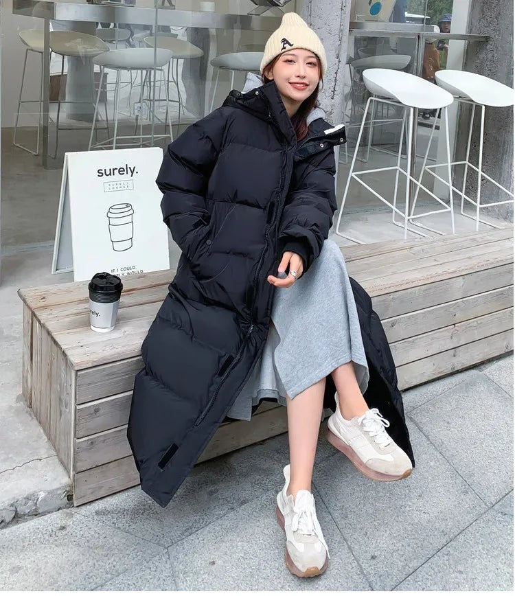 Schwarze lange Daunenjacke mit Kapuze, sitzend im Streetstyle-Look kombiniert