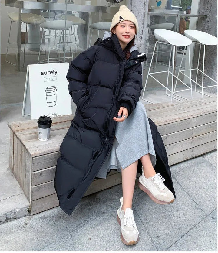 Schwarze lange Daunenjacke mit Kapuze, sitzend im Streetstyle-Look kombiniert