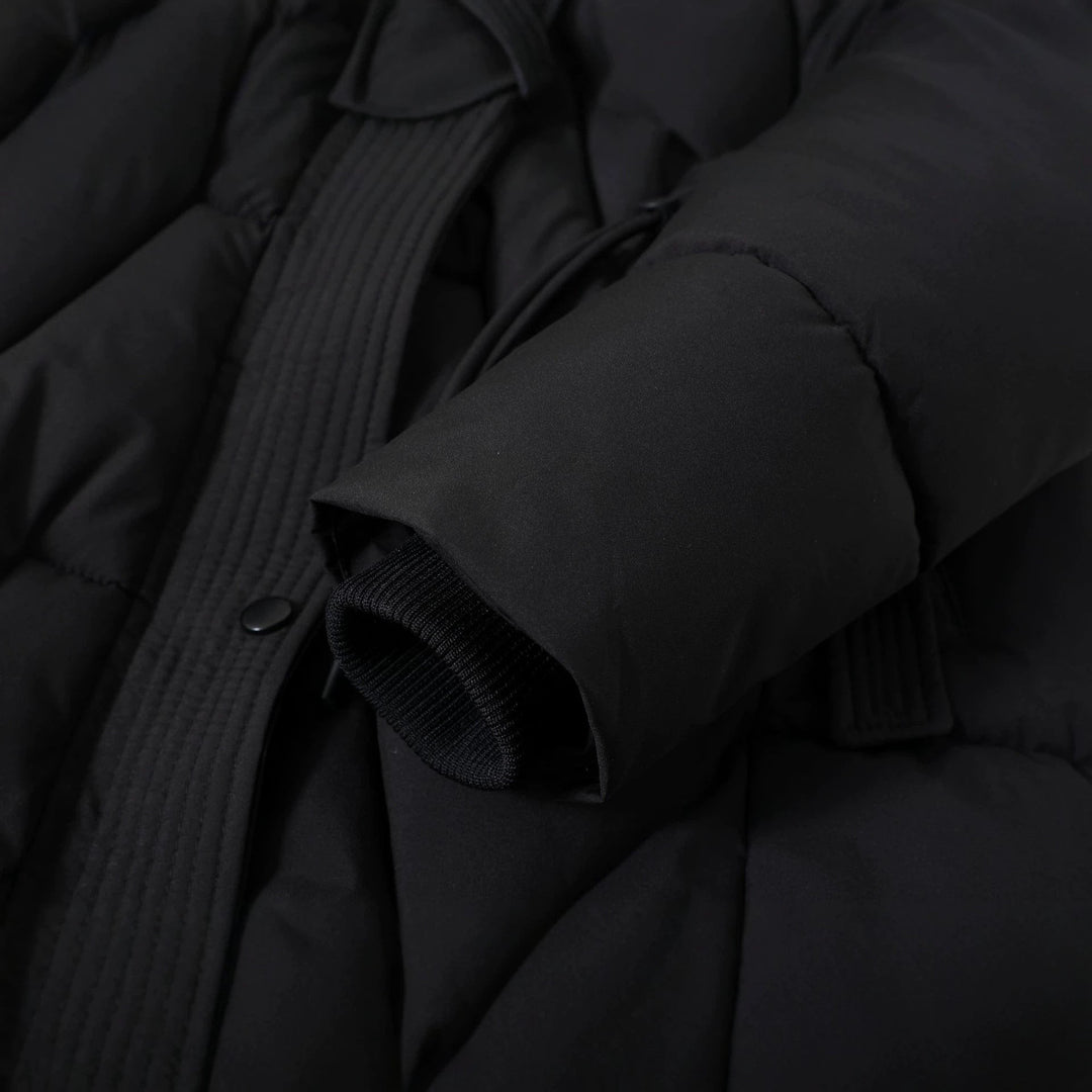 Detailansicht von Kordelzug, Druckknopf und Ärmelabschluss am schwarzen Parka