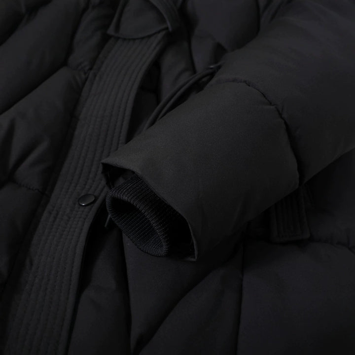 Detailansicht von Kordelzug, Druckknopf und Ärmelabschluss am schwarzen Parka