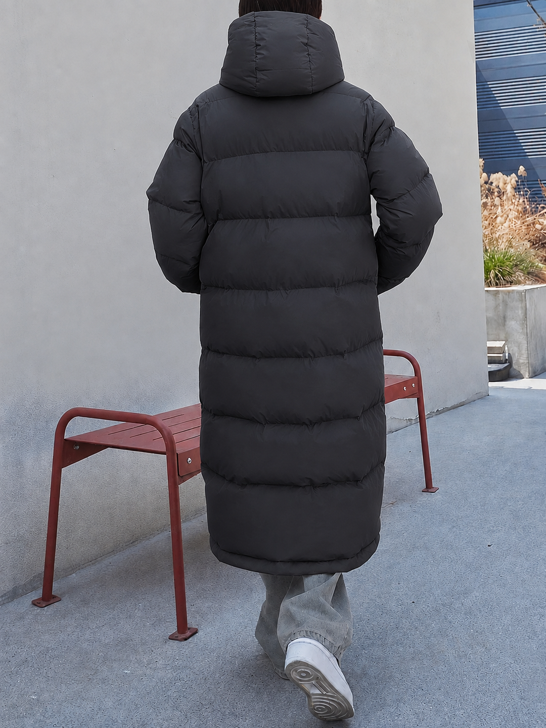 Rückansicht einer schwarzen langen Daunenjacke mit Kapuze und Steppdesign