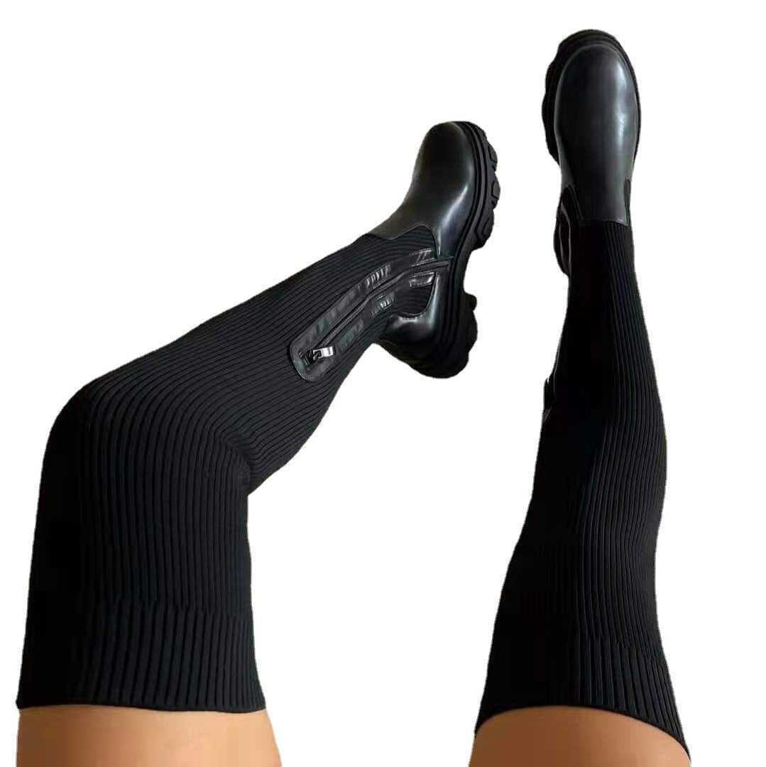 Schwarze Strickschaft-Boots mit Reißverschluss vor weißem Hintergrund