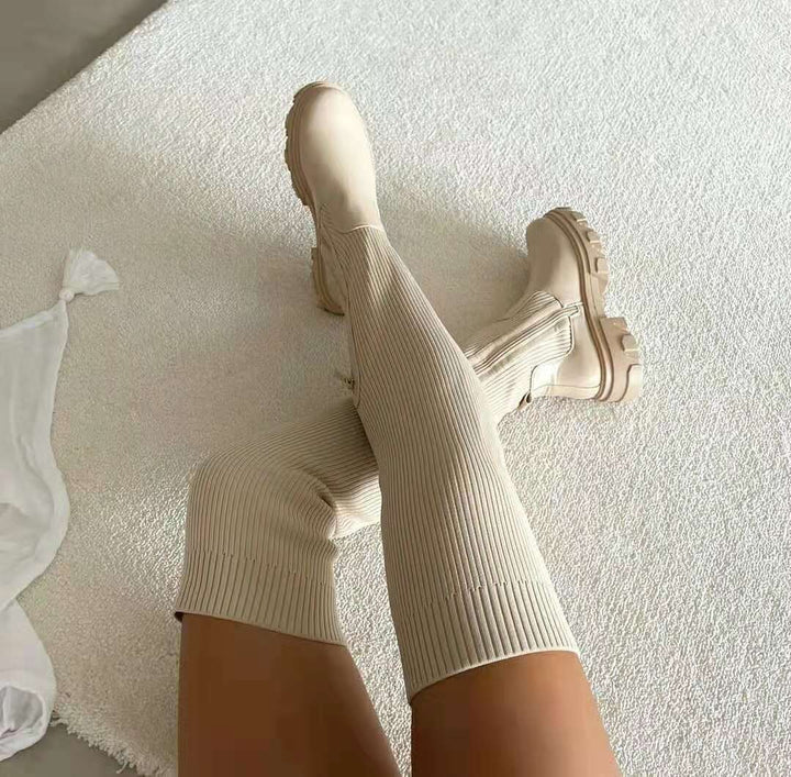 Beige Strickschaft-Boots mit robuster Profilsohle auf Teppich drapiert