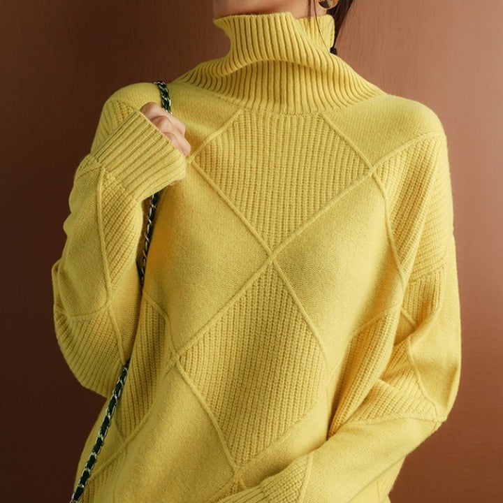 Gelber Rollkragenpullover mit Rautenmuster und Umhängetasche im Detail