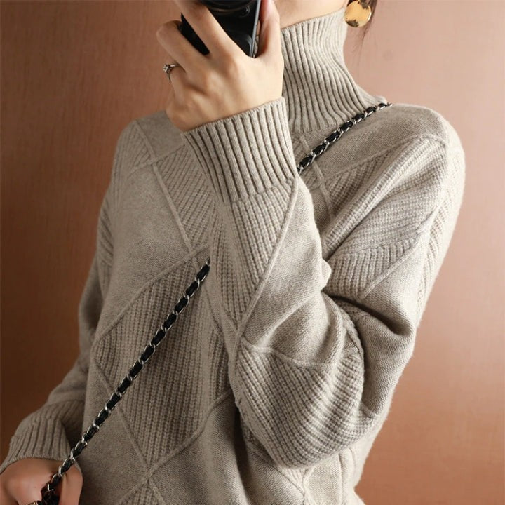 Taupefarbener Rollkragenpullover mit Rautenmuster und schwarzem Kettenriemen