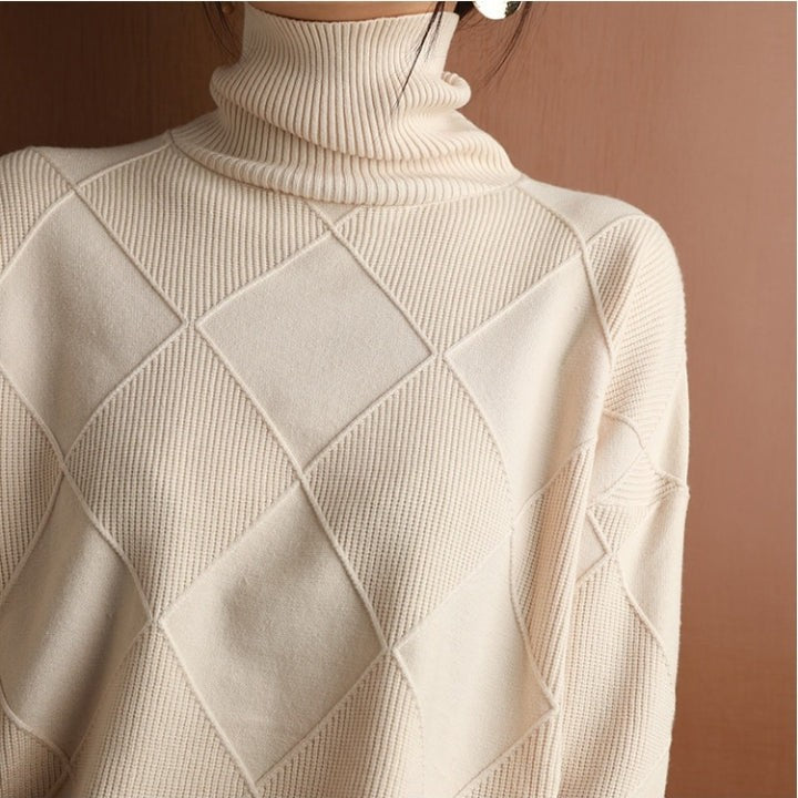 Nahaufnahme cremefarbener Strickpullover mit Rollkragen und Rautenmuster