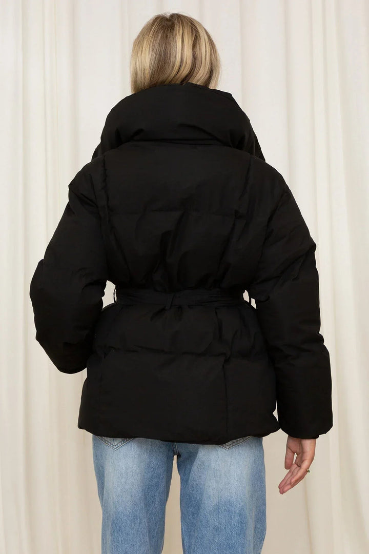 Rückenansicht schwarze Steppjacke mit Kapuze und geschnürtem Taillengürtel
