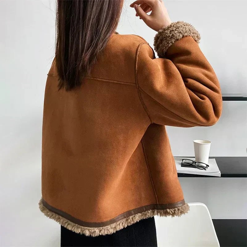 Rückansicht der braunen Fellimitat-Jacke mit Teddyfutter am Saum und Kragen