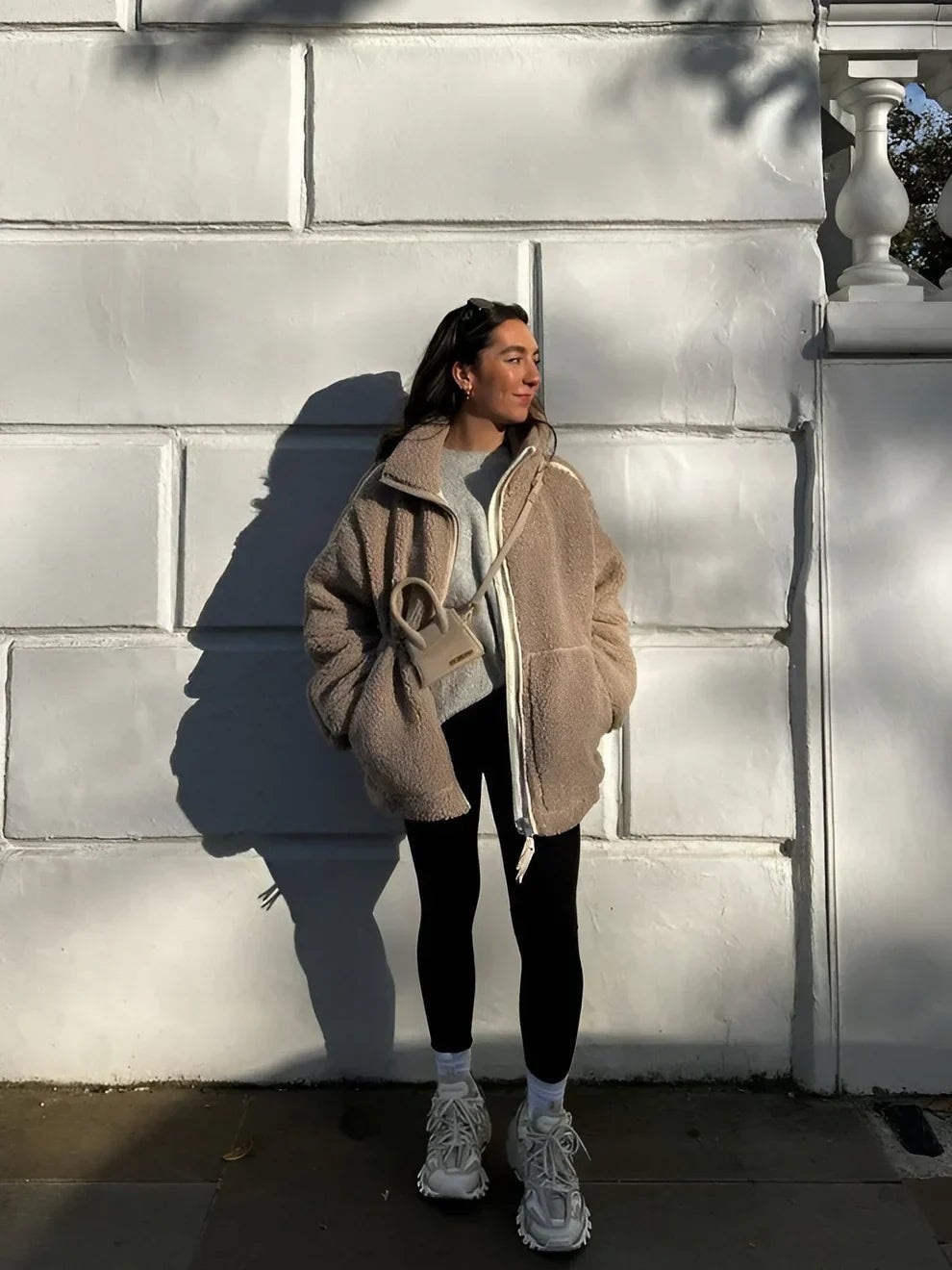 Beige Teddy-Jacke kombiniert mit schwarzer Leggings im Streetstyle-Look