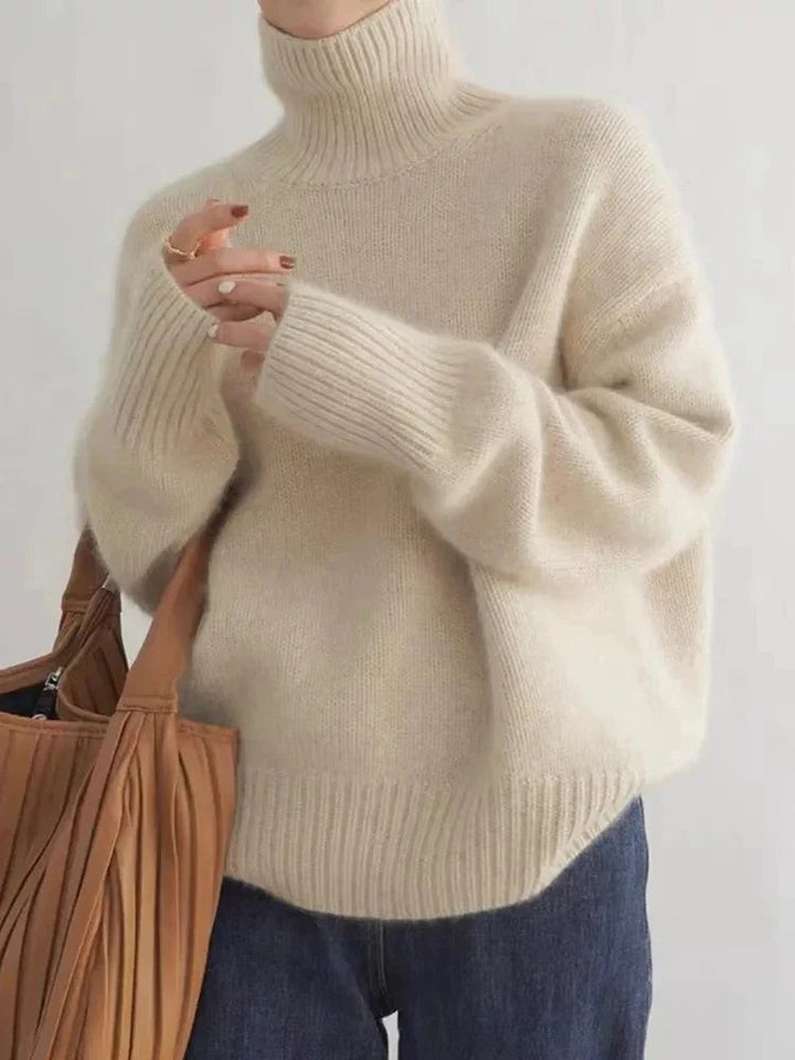 Cremefarbener Rollkragenpullover mit lockeren Ärmeln, kombiniert mit Jeans