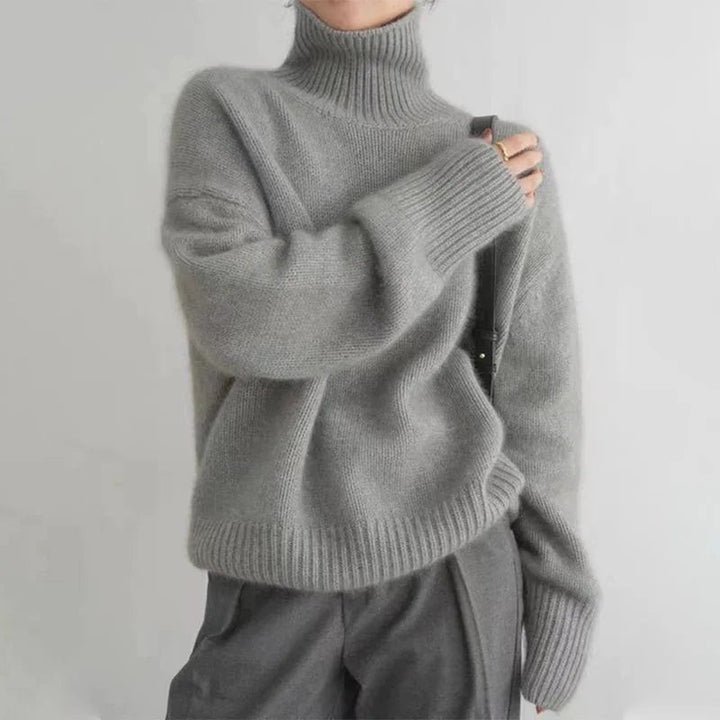 Grauer Strickpullover mit hohem Kragen und weiten Ärmeln