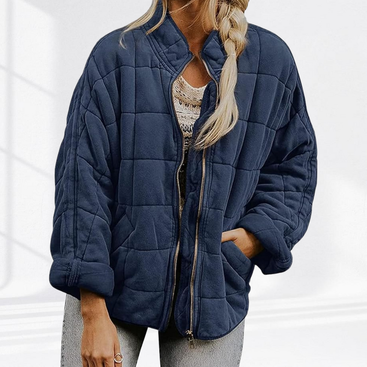 Marineblaue Steppjacke mit hohem Kragen, offen getragen mit geflochtenem Zopf