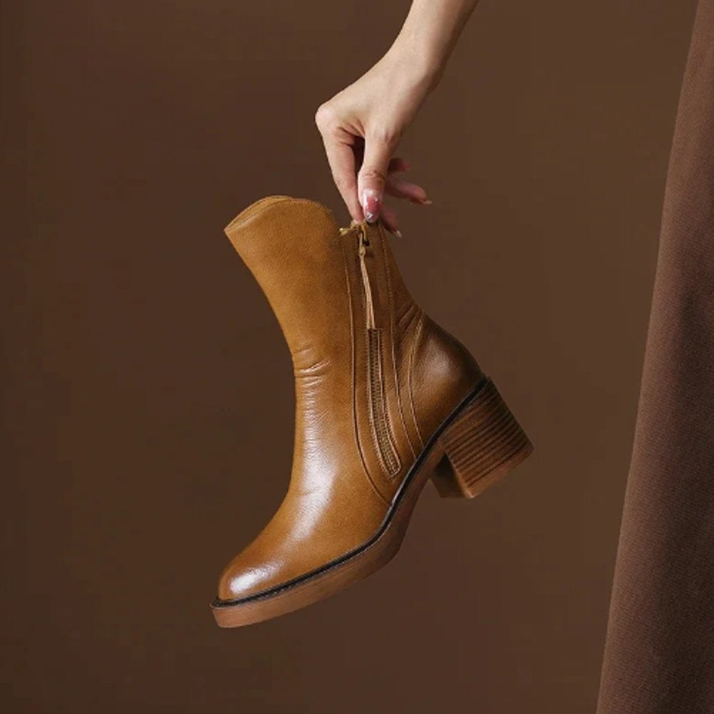 Cognacfarbener Ankle Boot aus Leder mit Blockabsatz in der Hand gehalten