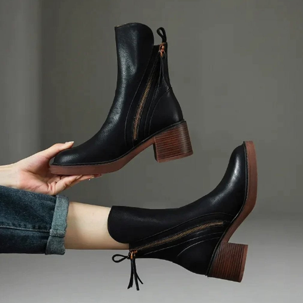 Schwarze Leder Ankle Boots mit Blockabsatz und seitlichem Reißverschluss präsentiert