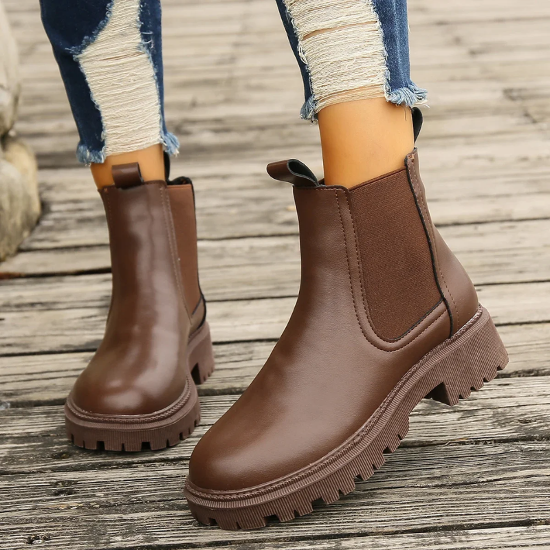 Braune Lederstiefel mit Zugschlaufe und Profilsohle im Stand