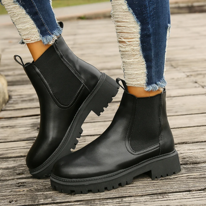 Schwarze Chelsea Boots aus Leder mit elastischem Seiteneinsatz getragen