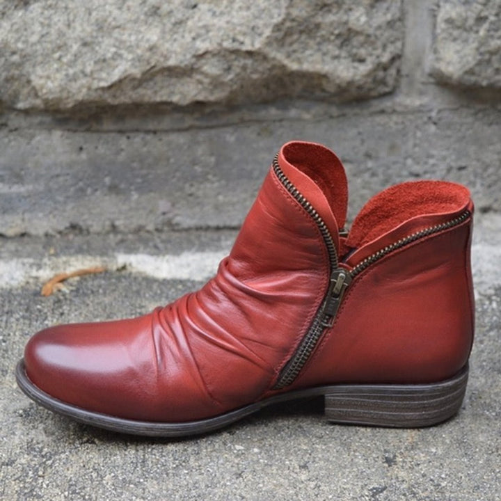 Rote Lederstiefelette mit gerafftem Schaft und auffälligem Metallreißverschluss
