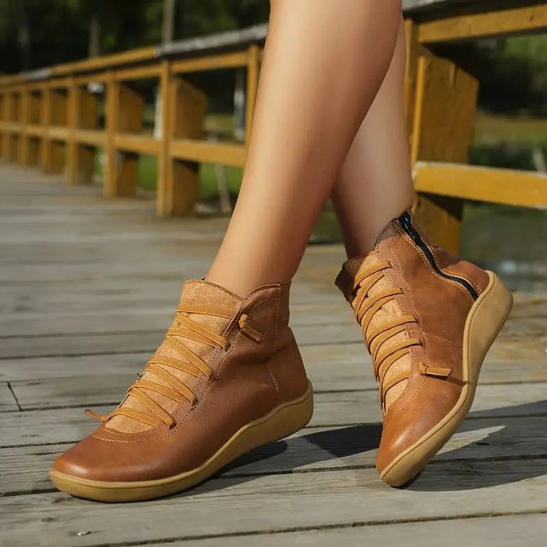 Braune Ankle Boots mit Schnürung, seitlich am Bein getragen