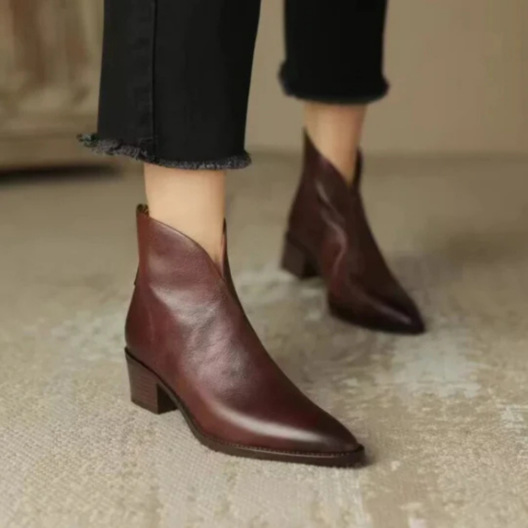 Dunkelbraune Lederstiefeletten am Fuß mit spitzer Schuhform