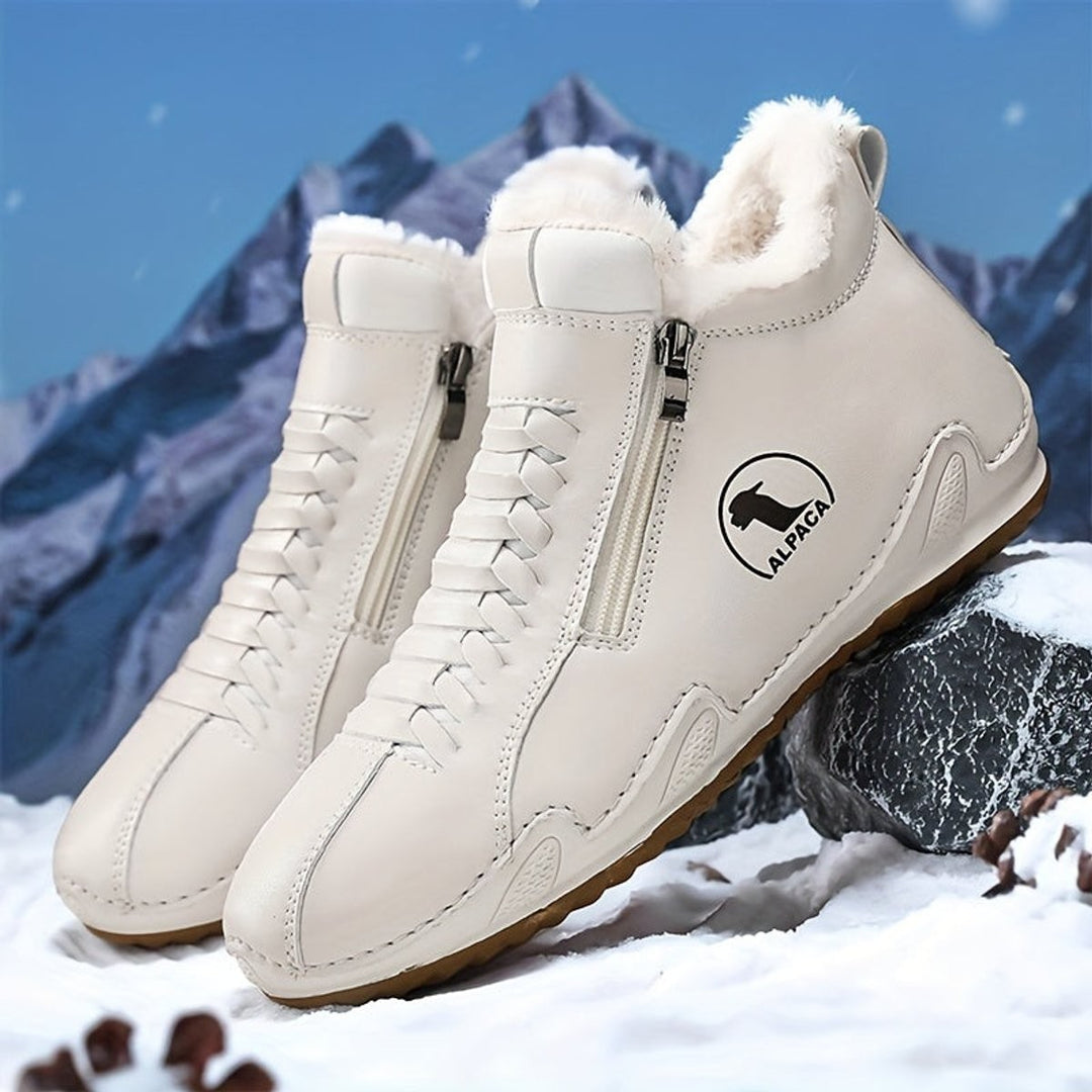 Cremefarbene gefütterte Winterboots mit Reißverschluss auf Schnee präsentiert