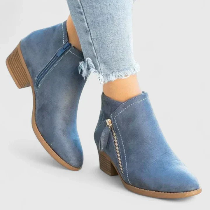 Blaue Stiefeletten mit goldenem Reißverschluss und Holzabsatz getragen