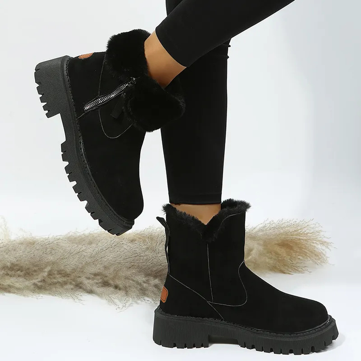 Schwarze Stiefeletten mit flauschigem Fellsaum und grober Laufsohle