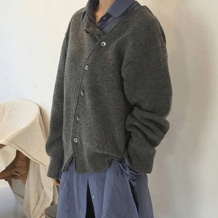 Grauer Strickcardigan mit asymmetrischer Knopfleiste über Hemdkragen kombiniert