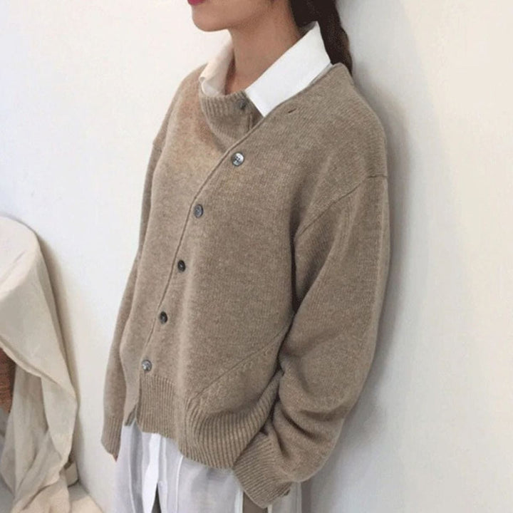 Beiger Strickcardigan mit schräger Knopfleiste über weißem Hemdkragen
