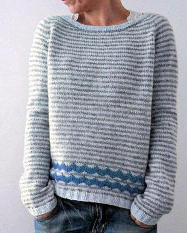 Grau-weiß gestreifter Strickpullover mit blauem Wellenmuster am Saum