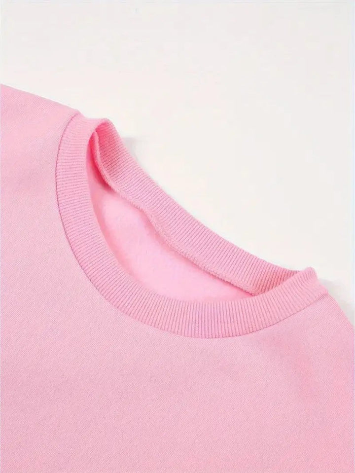 Nahaufnahme des gerippten Rundhalsausschnitts am rosa Sweatshirt